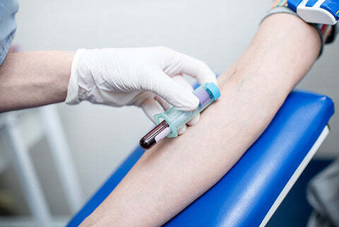 Phlebotomist draws blood from a patient.
